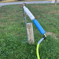 Two water filters stacked on each other, hooked to a spigot with a hose leading to an RV.