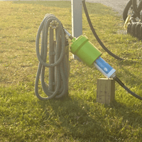 An inline water filter hooked to a spigot with a hose wrapped around the pedastal.