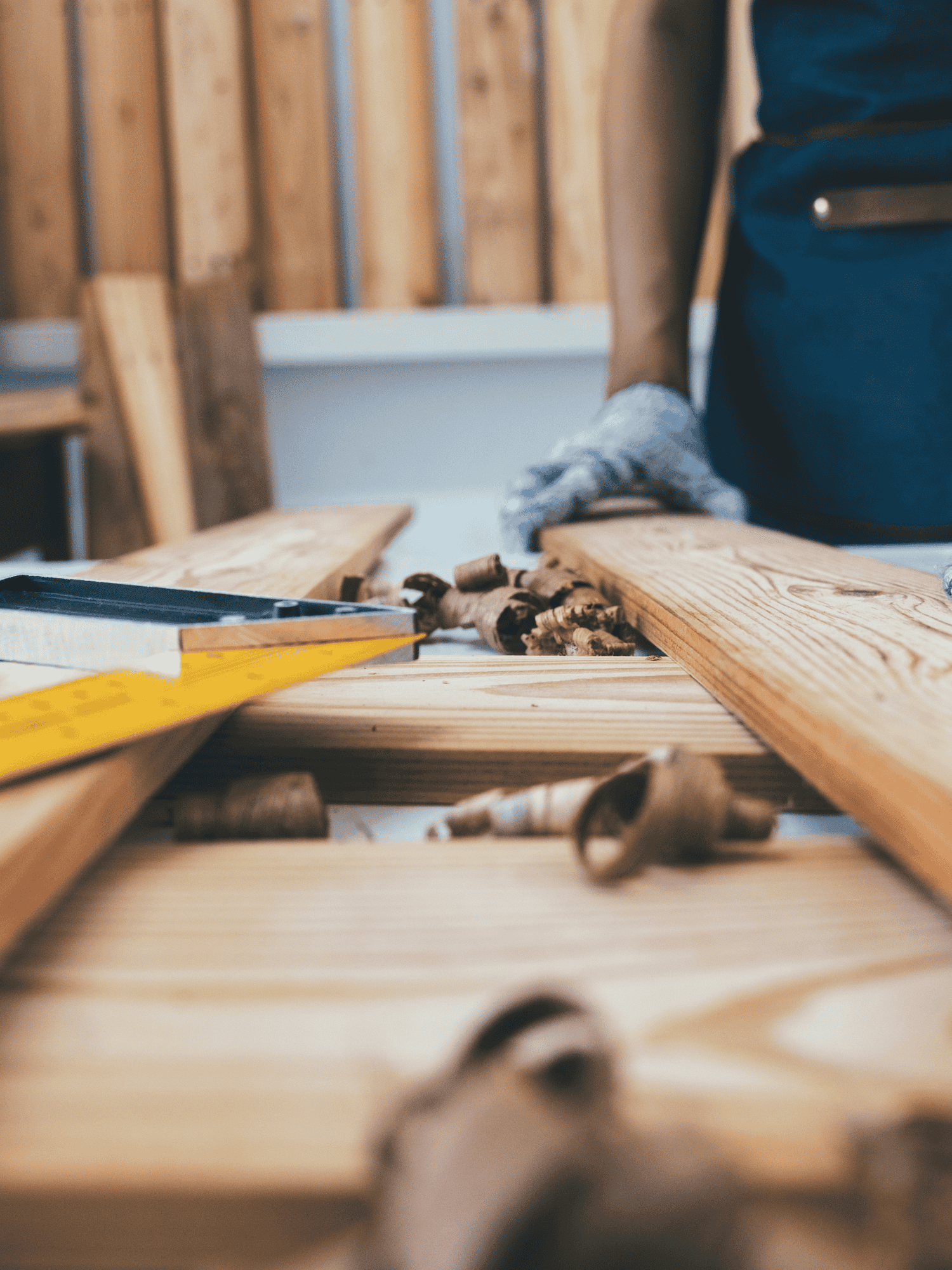 Woodworker with wood and wood shavings on a table.